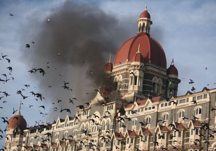 Pigeons fly near the burning Taj Mahal hotel in Mumbai November 27, 2008.