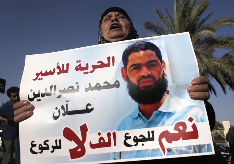 Maazouze, the mother of Mohammed Allaan, a Palestinian prisoner who is on a long-term hunger strike, holds a portrait of her son during a rally calling for his release.