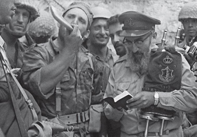 The iconic 1967 photo of Rabbi Shlomo Goren holding a Torah scroll as he leads the first Jewish prayer session at the Western Wall since 1948.