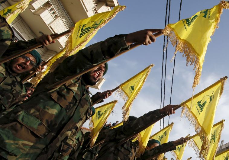 Lebanon's Hezbollah members carry Hezbollah flags during the funeral of Adnan Siblini, who was killed while fighting in Syria