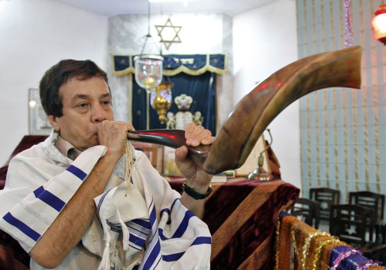 Ezekiel Isaac Malekar, honorary secretary of the Judah Hyam Synagogue synagogue, poses with a shofar horn inside the synagogue in New Delhi