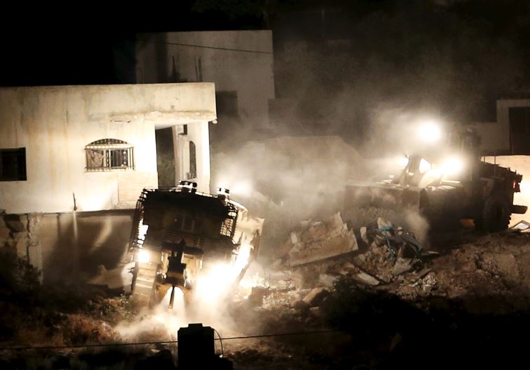 Israeli army machines demolish a Palestinian house during an Israeli raid in the West Bank city of Jenin