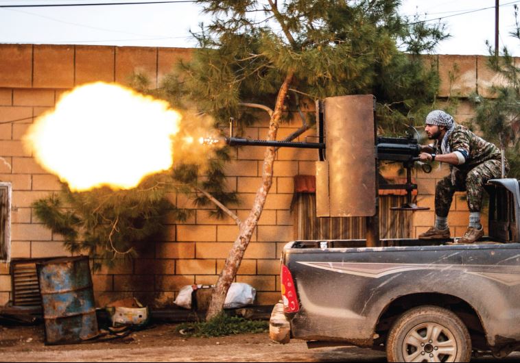 A militiaman of the Kurdish People’s Protection Units (YPG) in Tel Tawil village, northeast Syria, fires an anti-aircraft weapon in the direction of Islamic State fighters