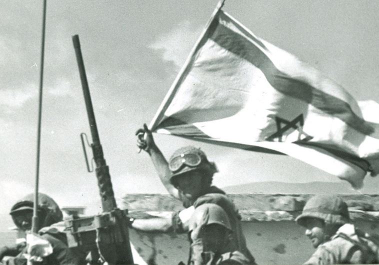 A soldier waves an Israeli flag on the Golan front during the Yom Kippur war.