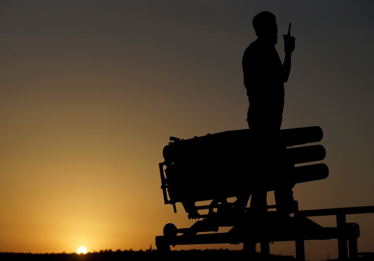 A Free Syrian Army fighter talks on a walkie-talkie near a rocket launcher in Daraa