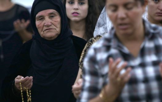 Iraqi Christians who fled the violence in the northern city of Mosul, pray at the MarAfram church in the village of Qaraqush, about 30 kms east of Mosul