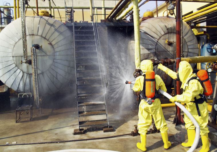 Firefighters use water to dilute ammonia leaking from a chemical plant