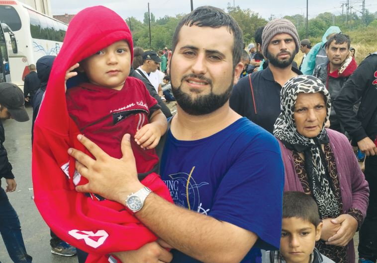 A family from Aleppo waits to cross into Macedonia. Thousands of migrants take this route towards Hungary and into the EU