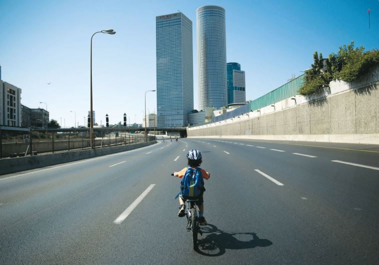 A boy rides his bike on the empty Ayalon highway on Yom Kippur