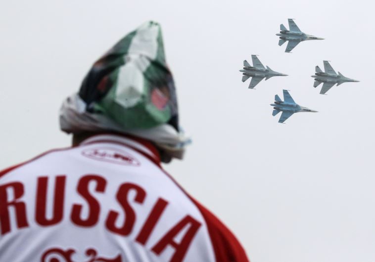 A spectator watches Sukhoi Su-30SM jet fighters of the Sokoly Rossii (Falcons of Russia) aerobatic team perform during the MAKS International Aviation and Space Salon in Zhukovsky, outside Moscow
