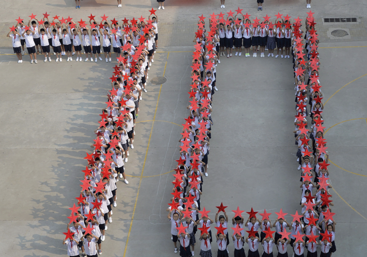STUDENTS FORM the figure ‘70’ earlier this month as they pose with Chinese national flags and red stars during an event to mark the 70th anniversary of the victory over Japan.