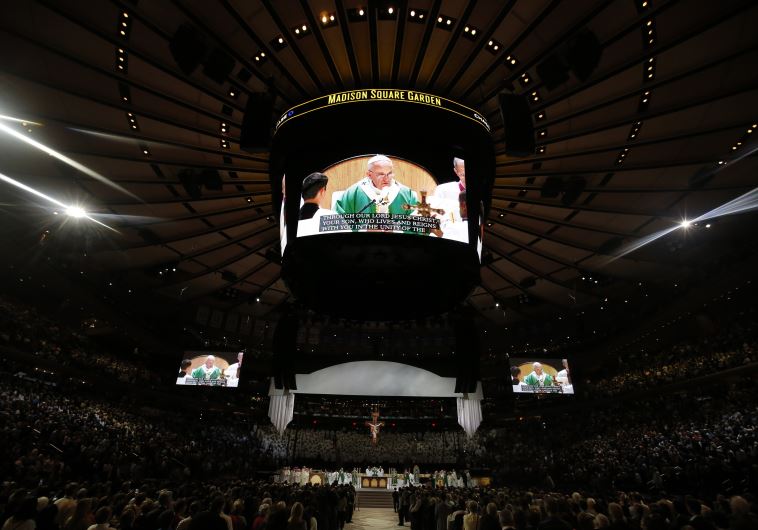 Pope Francis is shown on several large screens as he celebrates mass at Madison Square Garden in New York