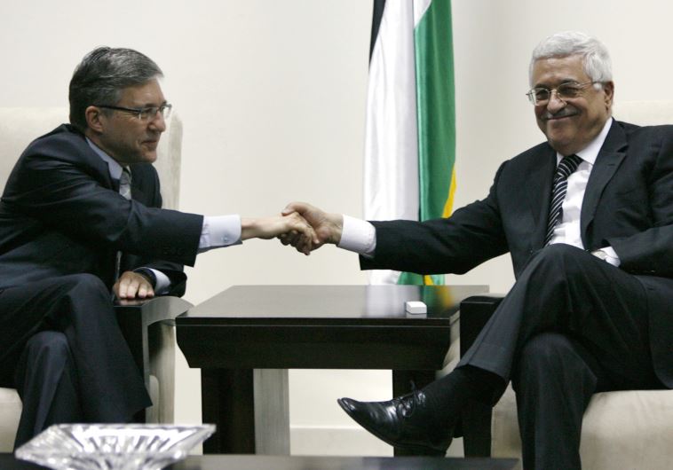 Palestinian Authority President Mahmoud Abbas (R) shakes hands with former justice minister Yossi Beilin