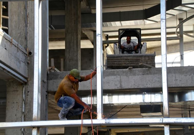 Construction workers build new mall at the Gush Etzion junction in the West Bank