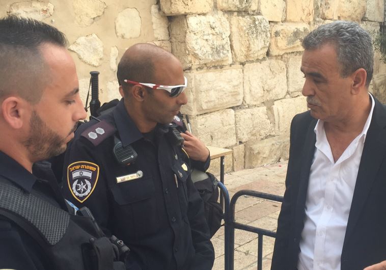 Zahalka with police officers banning him from Temple Mount