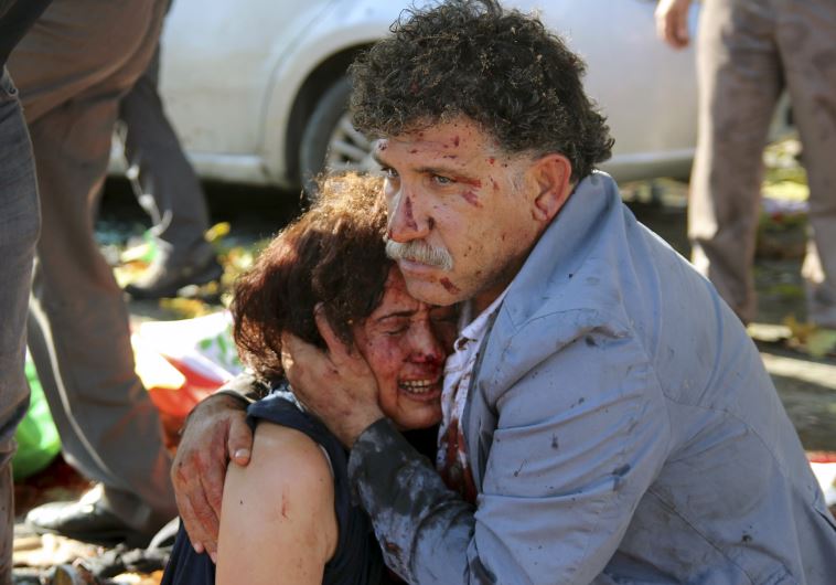An injured man hugs an injured woman after an explosion during a peace march in Ankara, Turkey, October 10, 2015.