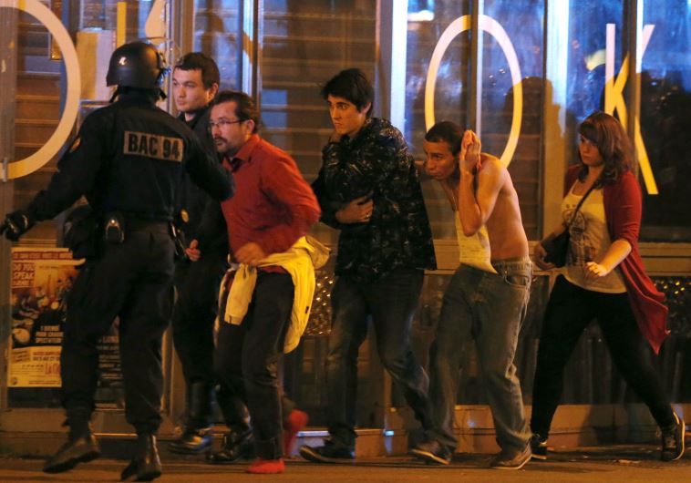 French special forces evacuate people, including an injured man holding his head, as people gather near the Bataclan concert hall following fatal shootings in Paris, France, November 13, 2015