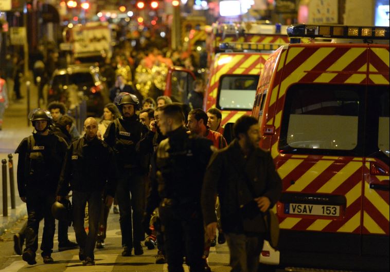 Police forces and rescuers walk through rue Oberkampf near the Bataclan concert hall in central Paris, early on November 14, 2015