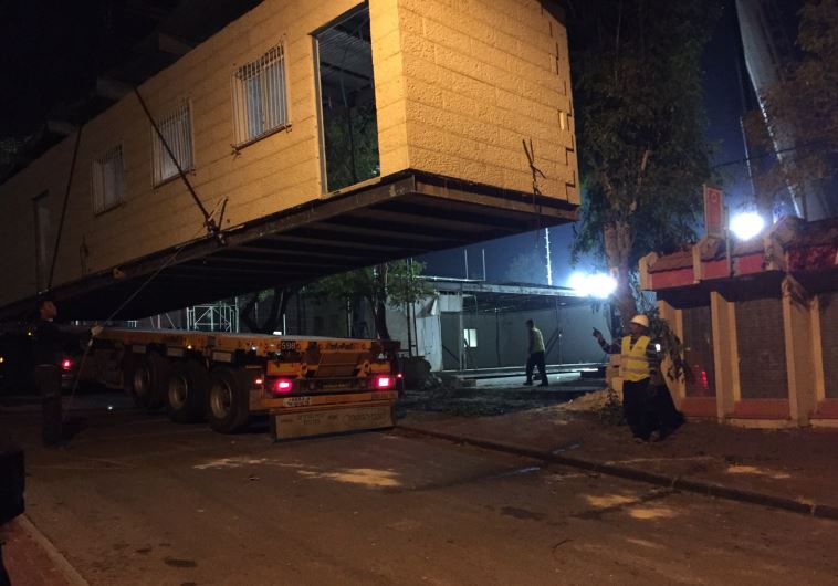 A temporary structure outside the controversial Givat Ze'ev synagogue being lifted onto a truck to be moved to a nearby public space