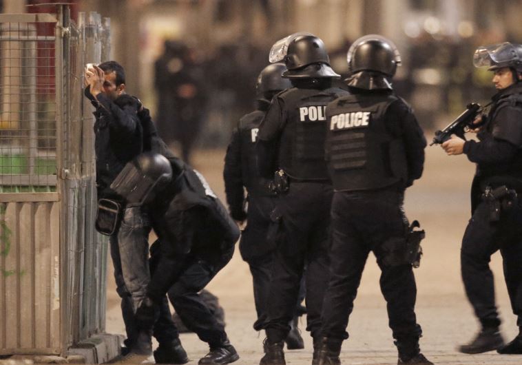 French spolice stop and search a local resident as shots are exchanged in Saint-Denis, France, near Paris