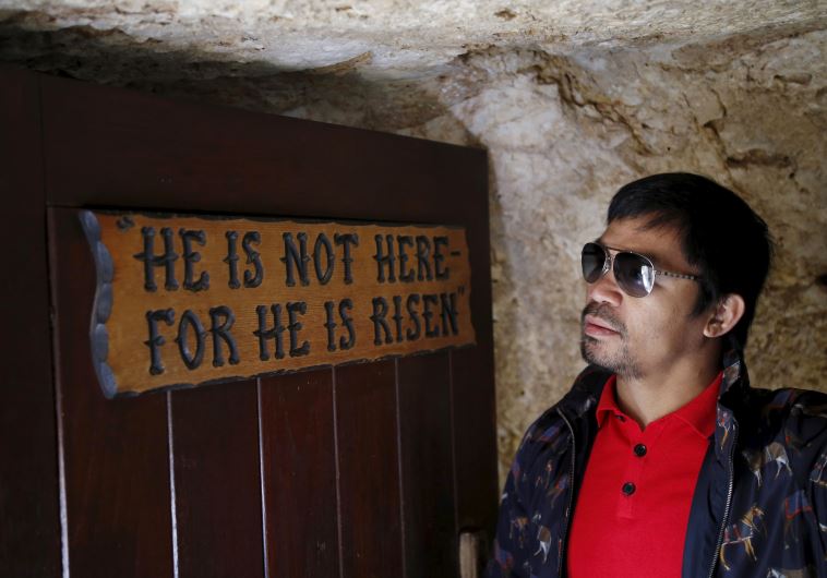 Filipino boxer Manny Pacquiao stands next to a sign during a visit to The Garden Tomb site outside Jerusalem's old city November 21, 2015