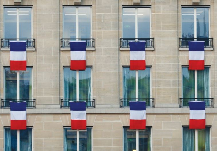TRICOLORES HANG from Paris windows on Friday in a tribute to victims of the terrorist attacks