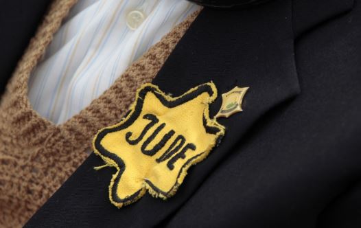 A Holocaust survivor wears a yellow star during a ceremony at the Yad Vashem Holocaust Memorial in Jerusalem