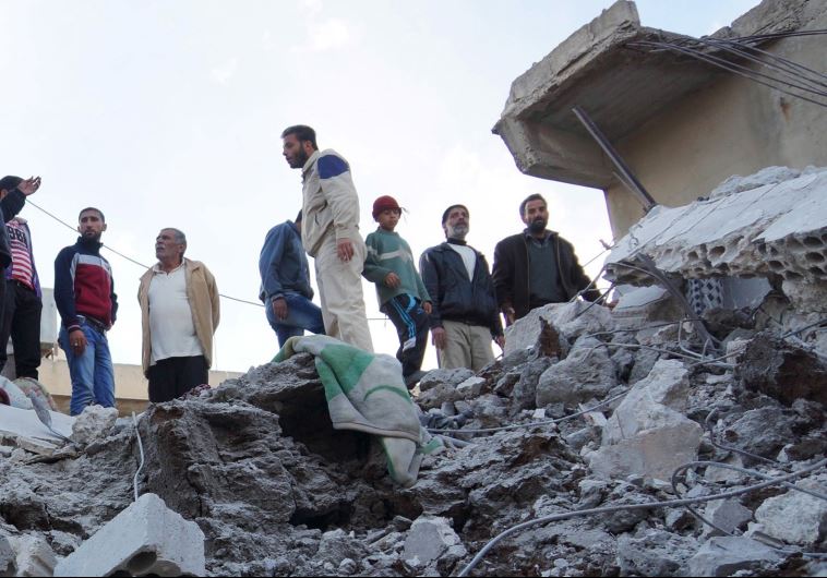 Residents of Nawa city in Syria inspect the damage after a reported strike against ISIS positions by the Russian Air Force, November 21