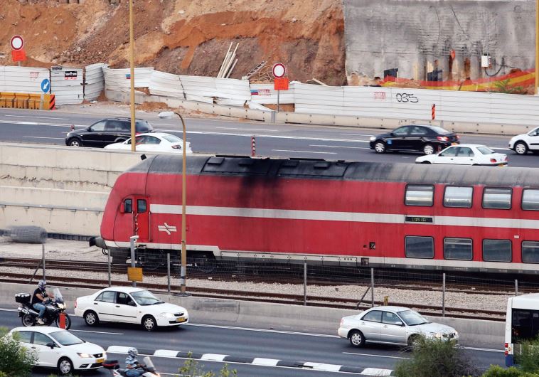 A train runs parallel to the Ayalon Highway in Tel Aviv