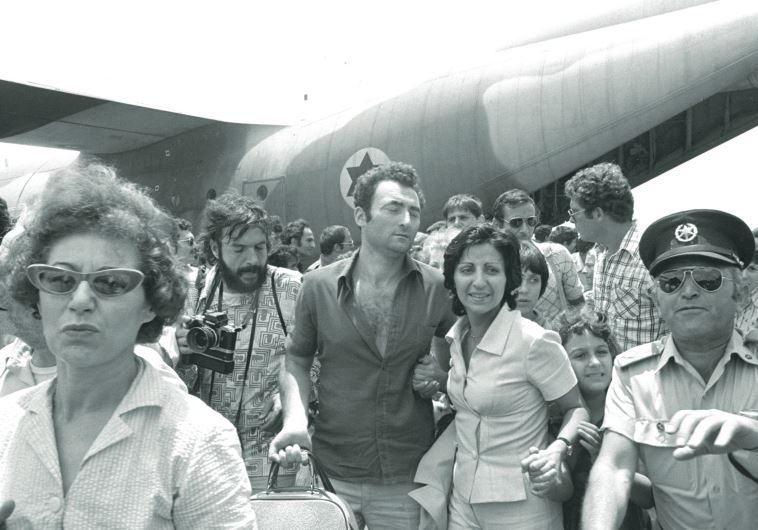 A police officer clears the way for rescued Air France hostages arriving in Tel Aviv after returning from Entebbe