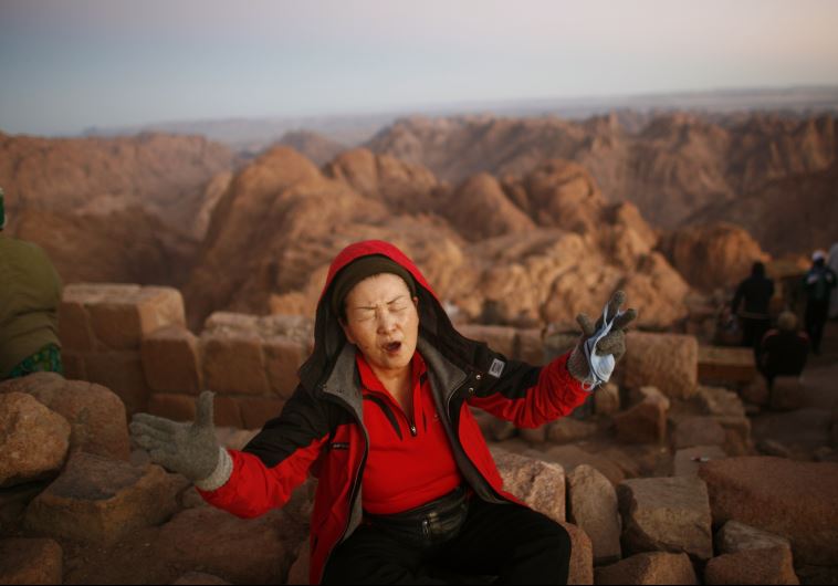 A worshipper prays outside a church on the summit of Mount Moses during sunrise on the Sinai Peninsula. According to the Old Testament, this is where Moses received the Ten Commandments from God
