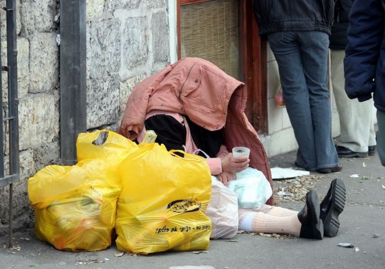 A homeless person begs for change in Israel