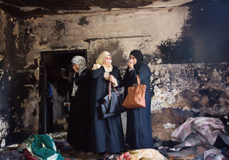 Photo of the Year: Menahem Kahana of the French AFP agency shows three Palestinian women standing in the Dawabsheh family home in the West Bank town of Duma, shortly after the arson that led to the deaths of an 18-month-old baby and his parents.