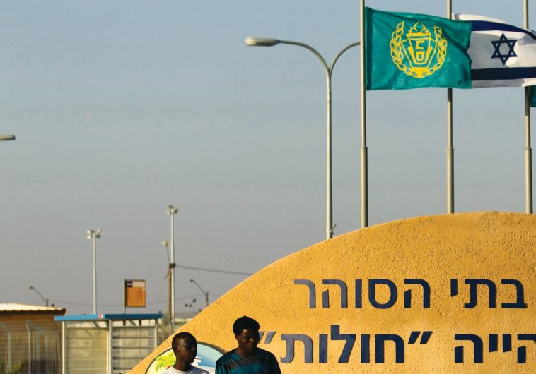AFRICAN REFUGEES are seen leaving the Holot detention facility.
