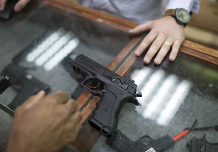 A man looks at guns in a gun shop in Tel Aviv, October 20, following a wave of stabbings by Palestinians that led Israelis to look to self-defense measures
