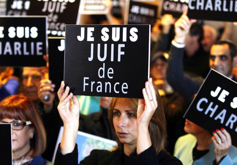 People hold up signs at a rally in Jerusalem, January 11, following terror attacks in France