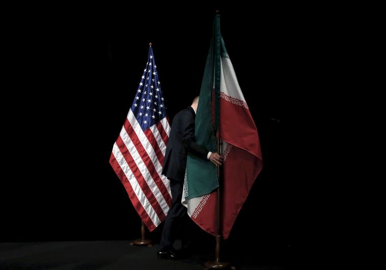 A staff member removes the Iranian flag from the stage during the Iran nuclear talks in Vienna, Austria July 14, 2015