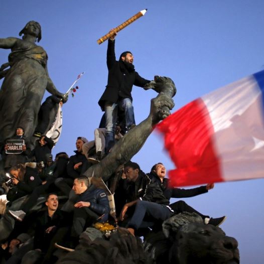 A man holds a giant pencil as he takes part in a solidarity march in the streets of Paris after the Charlie Hebdo shootings