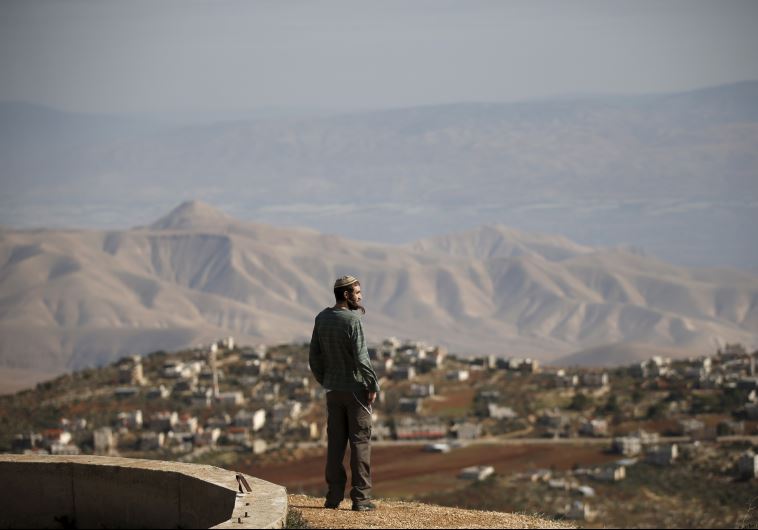 Jewish settler Refael Morris stands at an observation point overlooking the West Bank village of Duma, near Yishuv Hadaat, an unauthorized Jewish settler outpost