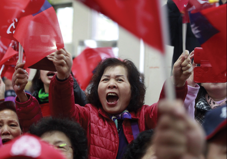 ENTHUSIASTIC SUPPORTERS of Taiwan’s ruling Nationalist Kuomintang Party (KMT) chairman Eric Chu wave flags during a campaign rally for the upcoming 2016 presidential election in Taoyuan, northern Taiwan.