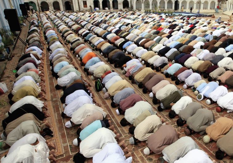 PAKISTANI MUSLIMS offer prayers on friday. The author argues that Palestinians he met were not very pious and were racist against Pakistanis.