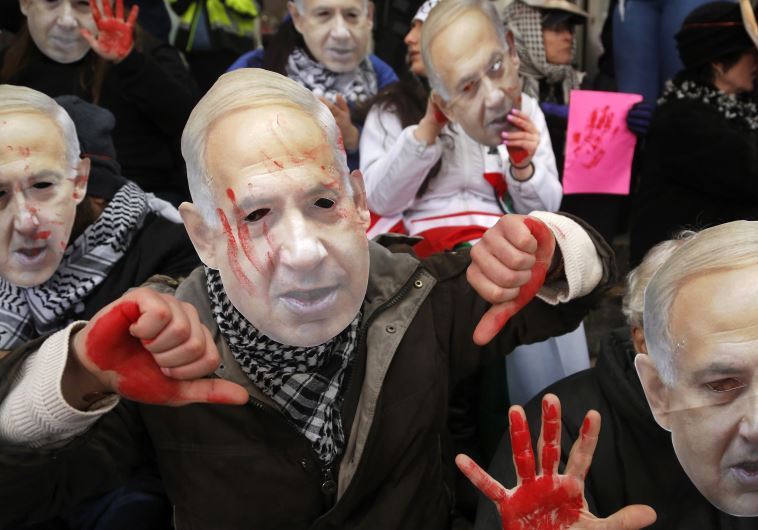 Anti-Israel demonstrators led by the protest group Code Pink wear masks of Prime Benjamin Netanyahu as they sit at the entrance to the AIPAC policy conference in Washington