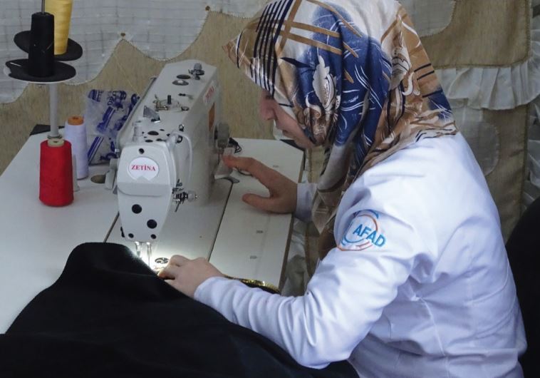 A WOMAN works at a sewing station in the Oncupinar refugee camp near Kilis at the Turkish-Syrian border. 