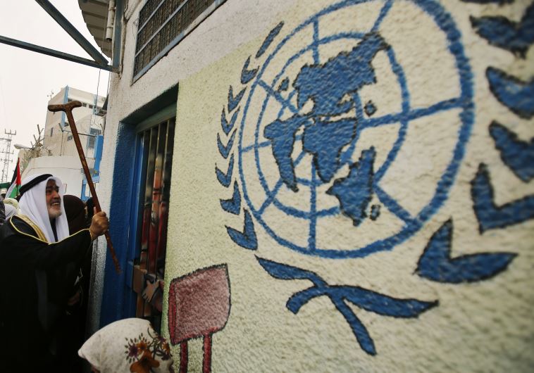 A Palestinian refugee knocks on the closed gate of the United Nations Relief and Works Agency (UNRWA) headquarters with his walking stick