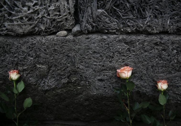 Flowers are placed at the "death wall" at the former Nazi German concentration and extermination camp Auschwitz-Birkenau in Oswiecim, Poland