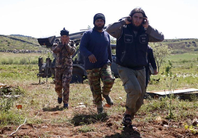 Rebel fighters from the Ahrar al-Sham Islamic Movement cover their ears during the launch of grad rockets from Idlib countryside towards forces loyal to Syria's President Bashar al-Assad, who are stationed at Jureen town in al-Ghab plain in the Hama countryside April 24, 2015.