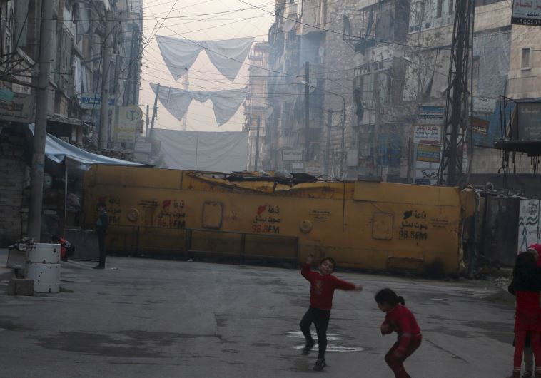 Children play near a bus barricading a street, which serves as protection from snipers loyal to Syria's President Bashar Assad, in Aleppo's rebel-controlled Bustan al-Qasr neighborhood, Syria April 6, 2016. 