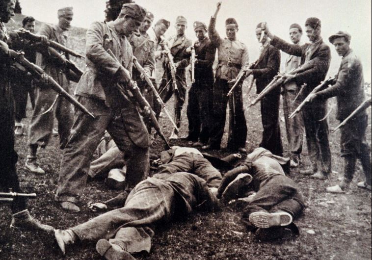 Victims of the Nazi-backed Ustasha regime killed at the end of the World War Two lay on the ground surrounded by posing Ustasha soldiers near the Sava River in Croatia in 1945