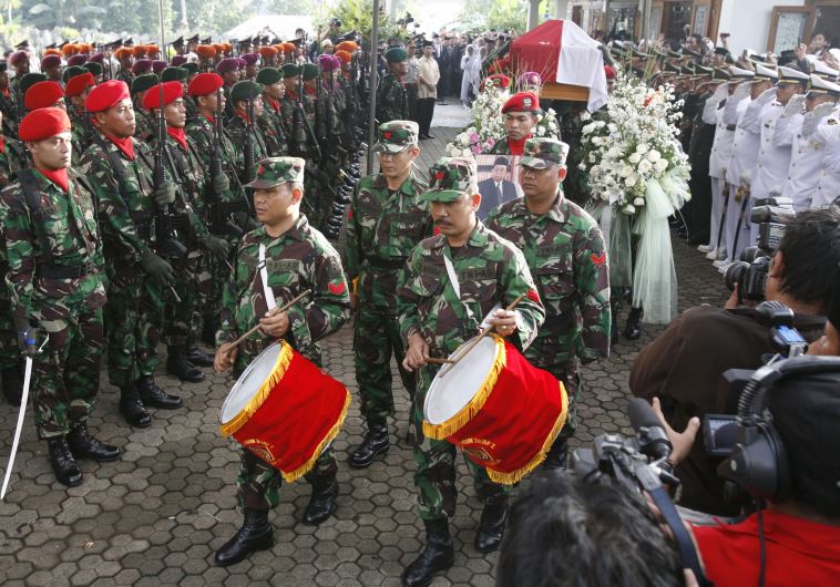 Soldiers carry the coffin of former Indonesian President Abdurrahman Wahid (also known as Gus Dur) as they leave the residence in Jakarta, December 31, 2009