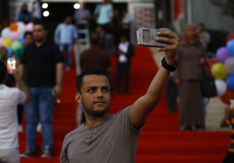A Palestinian man takes a selfie during the opening ceremony of the Red Carpet festival in Gaza City, on 12 May 2016.